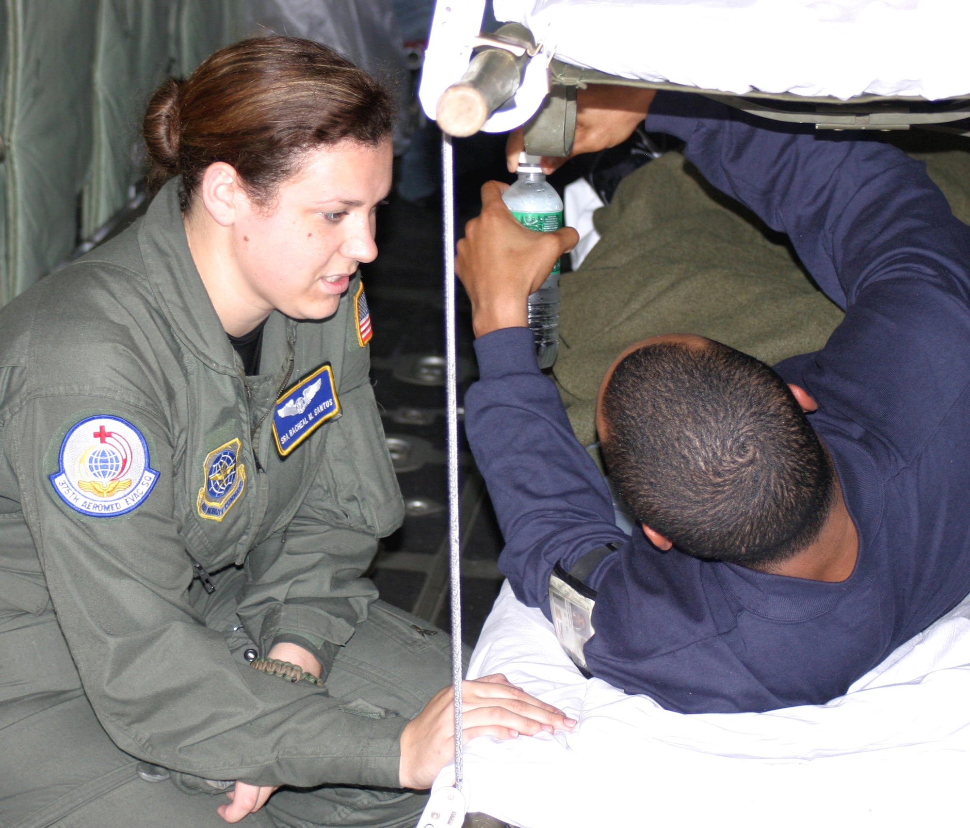 ANDREWS AIR FORCE BASE, Md. -- Senior Airman Racheal Santos comforts a patient during a recent aeromedical evacuation mission onboard a C-130 Hercules.  (U.S. Air Force photo by Master Sgt. Doug Moore)