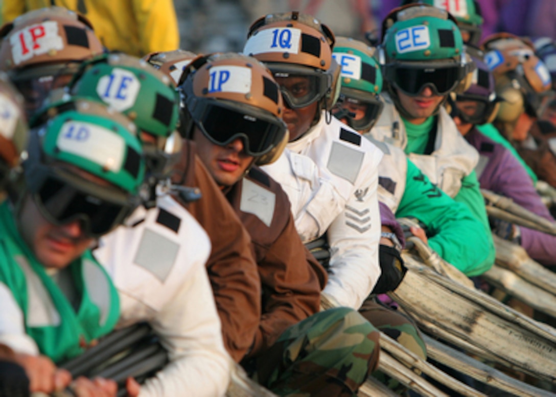 The flight deck crew of the aircraft carrier USS Harry S. Truman (CVN 75) waits for the signal to rig the crash barricade on the flight deck during a General Quarters drill in the Atlantic Ocean on July 27, 2005. The crash barricade is designed to snare incoming aircraft during an emergency. The Nimitz-class carrier is conducting carrier qualifications and sustainment operations off of the East Coast. 