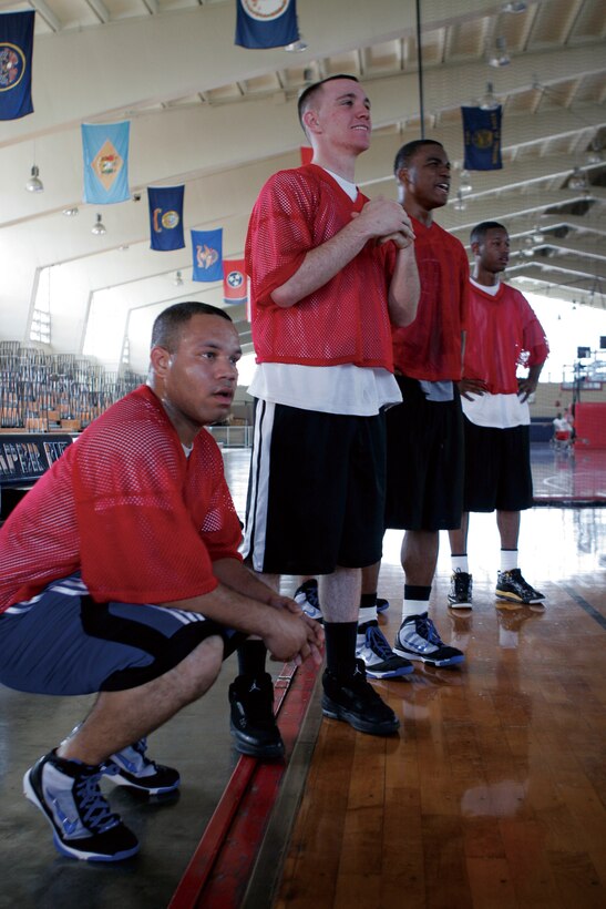 Marines from Engineer Maintenance Company, 3rd Maintenance Battalion, Combat Logistics Regiment 35, 3rd Marine Logistics Group, III Marine Expeditionary Force, wait on the sidelines to get back in the basketball game at the Camp Foster Field House March 13. The game was only one of the many being held to raise awareness of Marine Corps Community Services sporting events offered to service members.