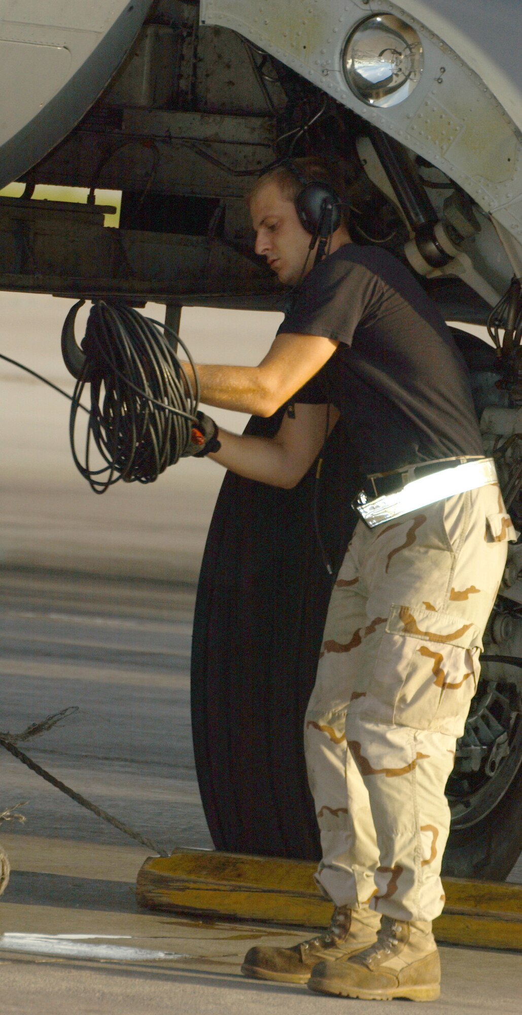 OPERATION ENDURING FREEDOM -- Senior Airman Vincent Tripodi packs up communication equipment used to talk to the cockpit crew before launching a B-52 Stratofortress.  He is a crew chief with the 40th Expeditionary Maintenance Squadron at a forward-deployed location and is from Minot Air Force Base, N.D.  (U.S. Air Force photo by Staff Sgt. Jocelyn Rich)              