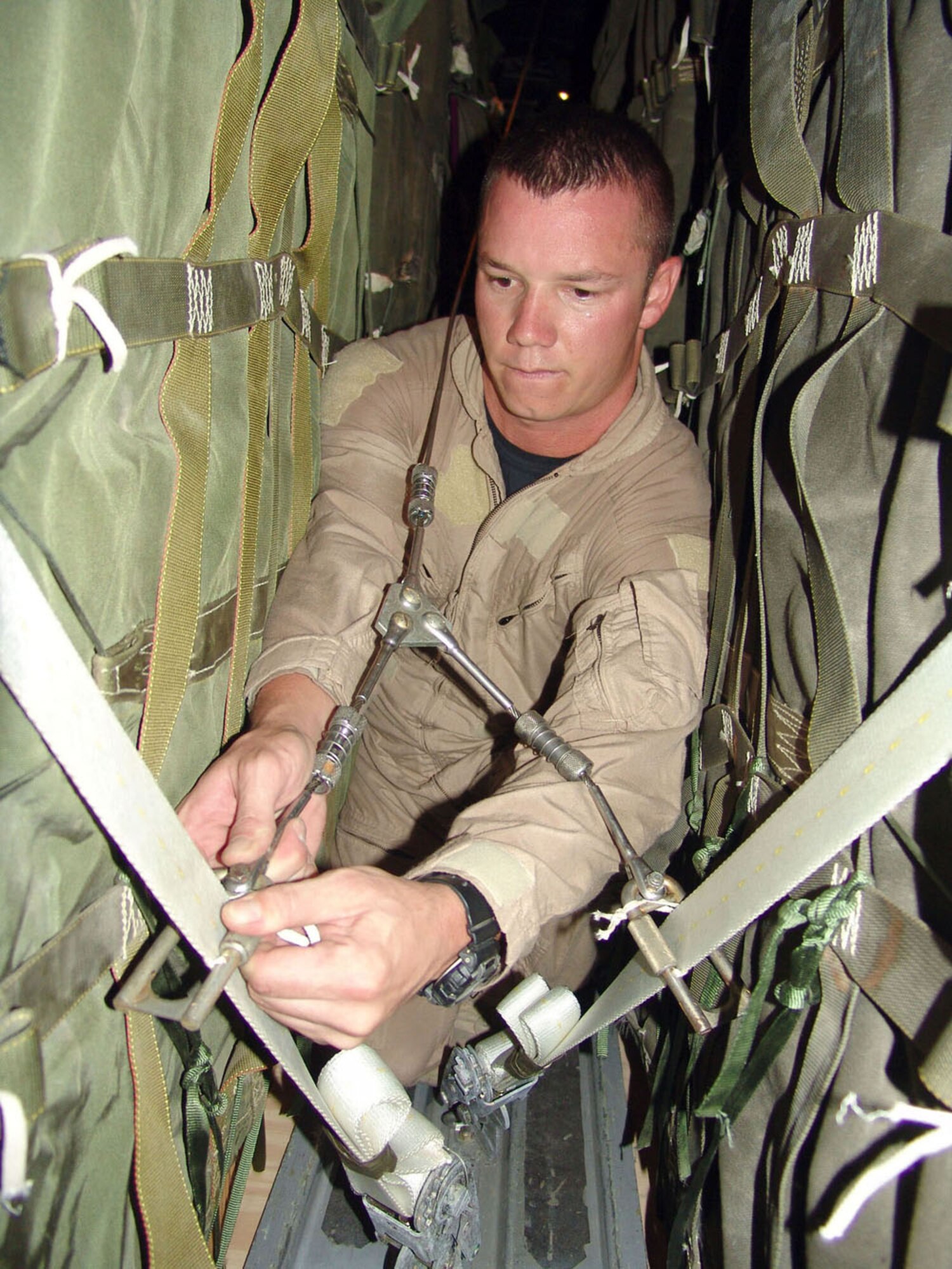 SOUTHWEST ASIA -- Senior Airman David Sanders installs a guillotine knife and Y-adapter extraction cable used for container delivery system airdrops.  This airdrop mission delivered 48 bundles containing about 69,000 pounds of food rations for U.S. and Iraqi Soldiers engaged in combat operations against anti-Iraqi forces.  Airman Sanders is a loadmaster with the 737th Expeditionary Airlift Squadron at a forward-deployed location and is from Pope Air Force Base, N.C.  (U.S. Air Force photo by Master Sgt. Al Gerloff)