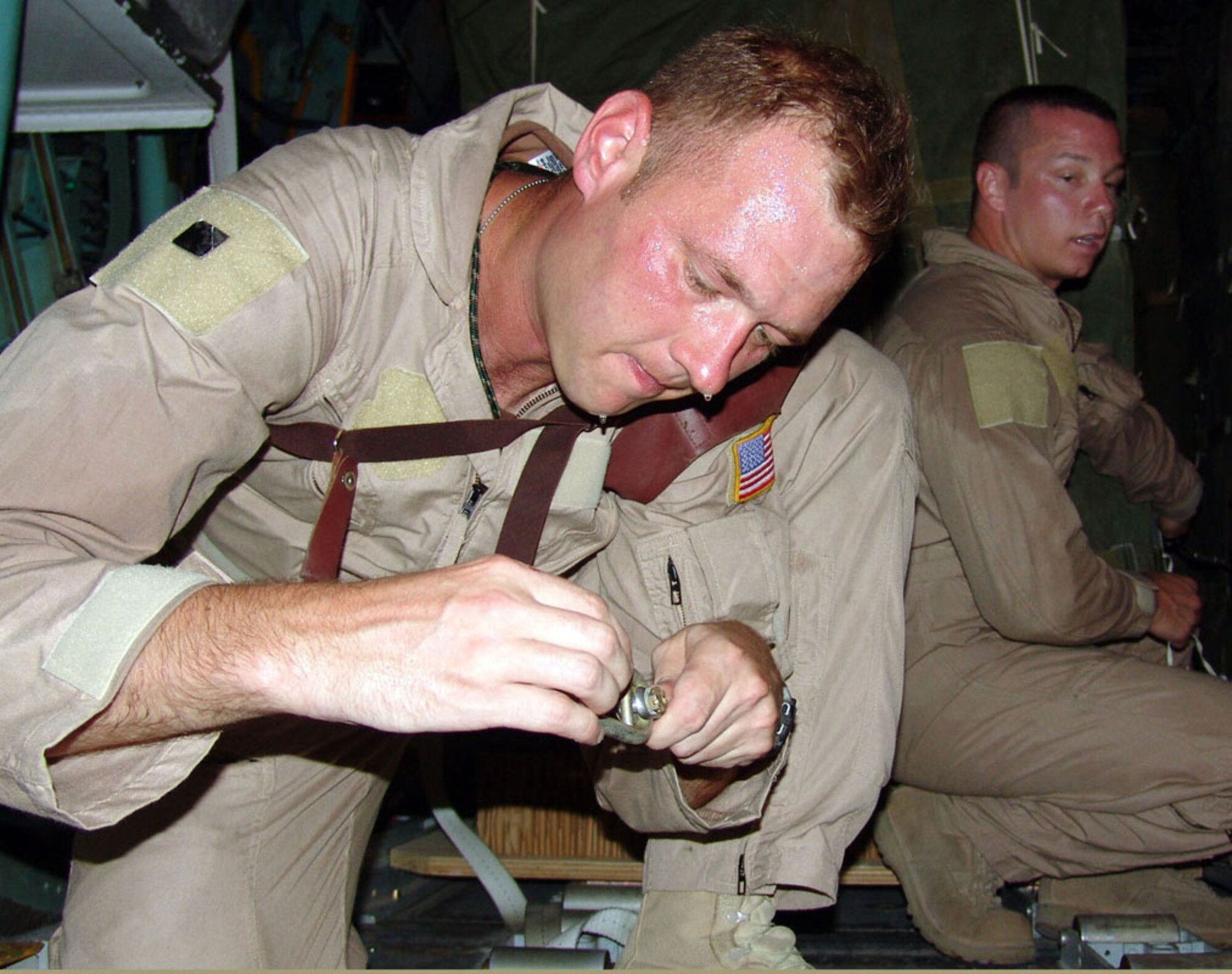 SOUTHWEST ASIA -- Tech Sgt. Scottie Turner (left) and Senior Airman David Sanders prepare a guillotine knife and Y-adapter extraction cable used for container delivery system airdrops.  This airdrop mission delivered 48 bundles containing about 69,000 pounds of food rations for U.S. and Iraqi Soldiers engaged in combat operations against anti-Iraqi forces.  The Airmen are loadmasters with the 737th Expeditionary Airlift Squadron at a forward-deployed location and are from Pope Air Force Base, N.C.  (U.S. Air Force photo by Master Sgt. Al Gerloff)