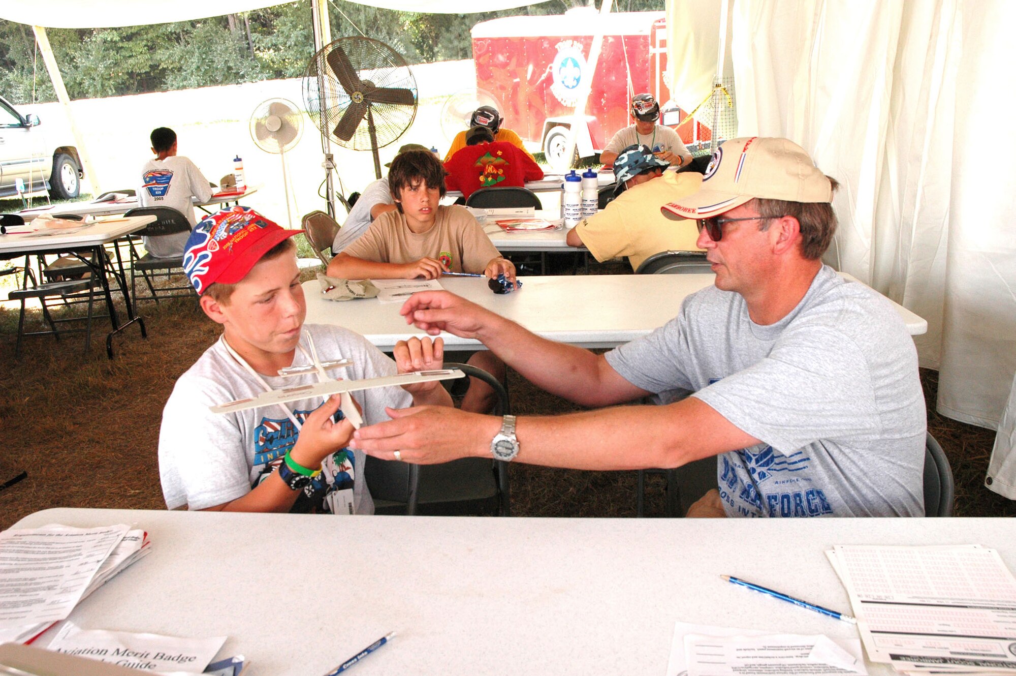 FORT A.P. HILL, Va. -- Retired Lt. Col. Jeff Ball helps a Boy Scout earn an aviation merit badge at the 2005 National Scout Jamboree by teaching him the fundamentals of powered flight.  Retired and active-duty Air Force pilots, civilian pilots, certified flight instructors and even a Navy pilot helped nearly 1,000 Boy Scouts earn their aviation merit badge during the 10-day Jamboree.  (U.S. Air Force photo by Staff Sgt. C. Todd Lopez)