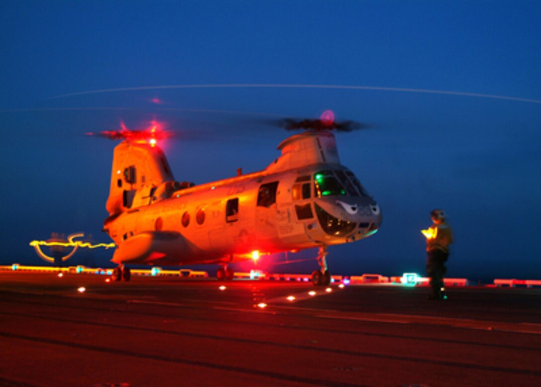 A U.S. Navy Landing Signal Enlisted prepares a CH-46 Sea Knight helicopter for lift-off from the flight deck of the USS Tarawa (LHA 1) while the ship operates at sea on July 29, 2005. Tarawa is the flagship for Expeditionary Strike Group 1 and is on a Western Pacific deployment in support of Operation Iraqi Freedom. 