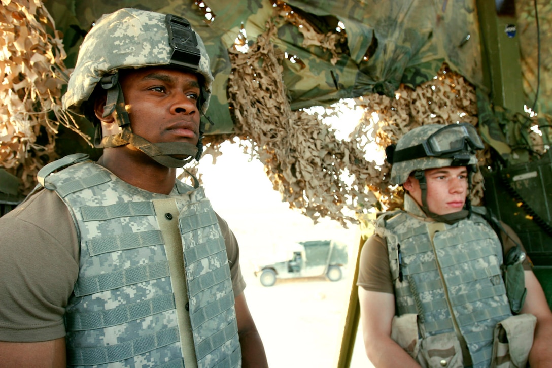 AL ASAD, Iraq ? Specialists Lee Davenport (left) and Ben Norton, tower guards with the 1st Battalion of the 109th (Mechanized) Infantry, keep a watchful eye on the terrain around them to ensure there is no enemy activity in the vicinity of the air base Aug. 5.  The soldiers arrived here recently and assumed the force protection mission of providing interior security for this former Iraqi air base and conducting convoy security missions throughout western Iraq.
