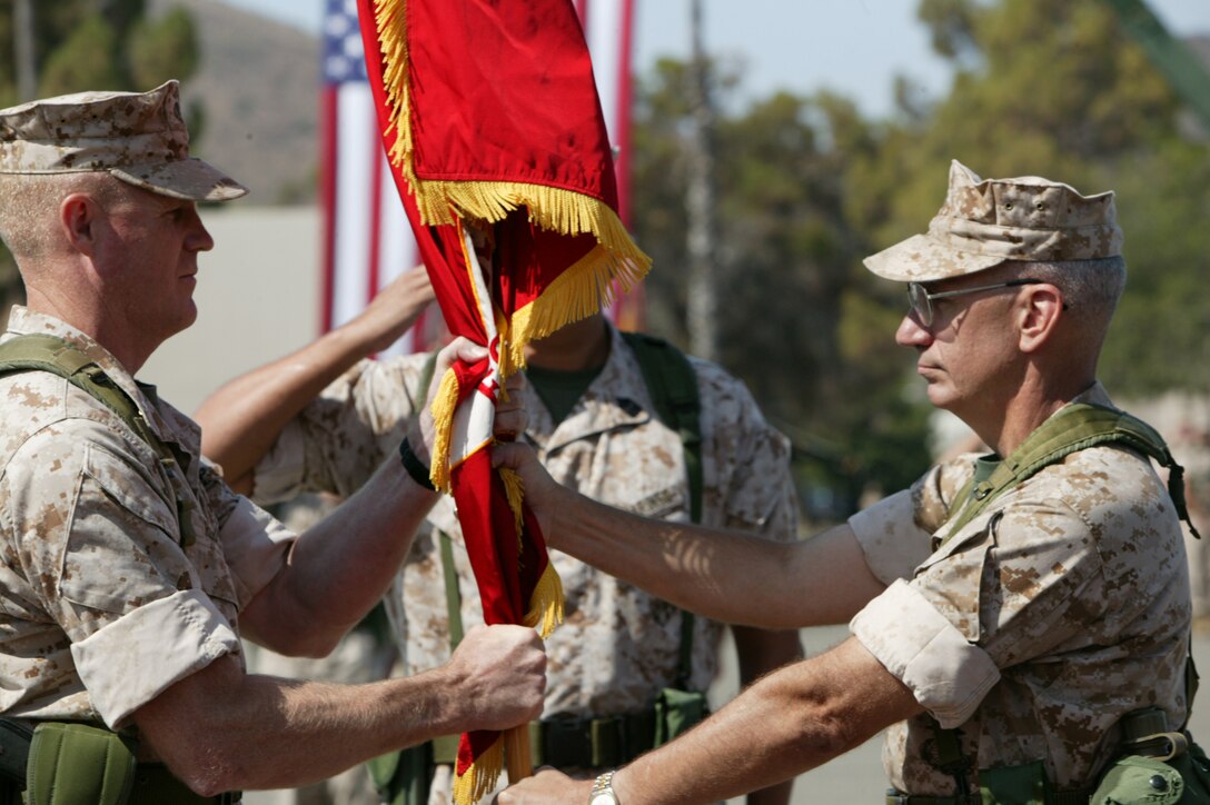 Brig. Gen. David G. Reist, left, assumes command of the 1st Force Service Support Group from Maj. Gen. Richard S. Kramlich during a change of command ceremony Friday at the 22 Area parade deck. Reist, Kramlich's former chief of staff, will lead the 8,900 Marines and sailors within the 1st FSSG to a third tour in Iraq next year.