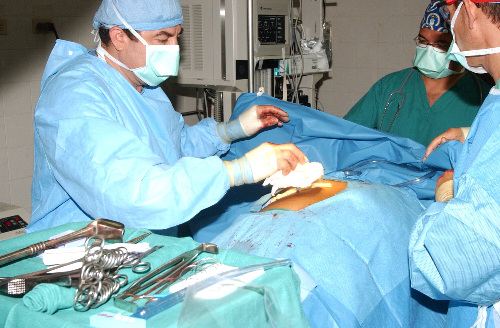 COMAYAGUA, Honduras -- (From left) Dr. Jose Angel Mejia cleans off a patient as Capt. Said Acosta and Army Col. (Dr.) Craig Shriver assist.  The group performed surgery on the patient to remove a swollen gallbladder during a medical readiness training exercise here.  Dr. Mejia is a Honduran doctor.  Captain Acosta and Dr. Shriver are with the Joint Task Force-Bravo's medical element at nearby Soto Cano Air Base.  (U.S. Air Force photo by Tech. Sgt. Cheri Dragos-Pritchard)                            