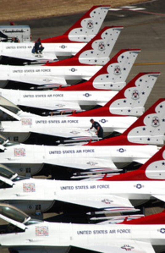 Maintenance personnel from the U.S. Air Force's Thunderbirds give the brightly painted F-16 Fighting Falcons a quick wash at McChord Air Force Base, Wash., on July 30, 2005. The team is setting up to perform at thee two-day 2005 Air Expo, at McChord. 