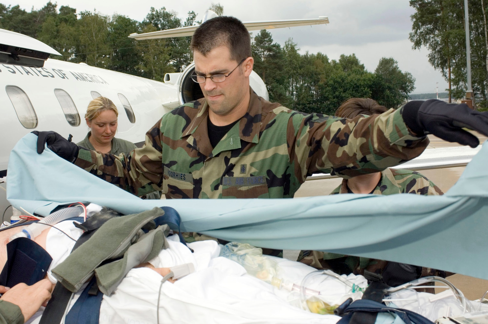 RAMSTEIN AIR BASE, Germany -- Tech. Sgt. David Voorhies covers a critical patient before he is transported to nearby Landstuhl Regional Medical Center. He is assigned to the 435th Contingency Aeromedical Staging Facility here and is deployed from Lackland Air Force Base, Texas. (U.S. Air Force photo by Master Sgt. John E. Lasky)