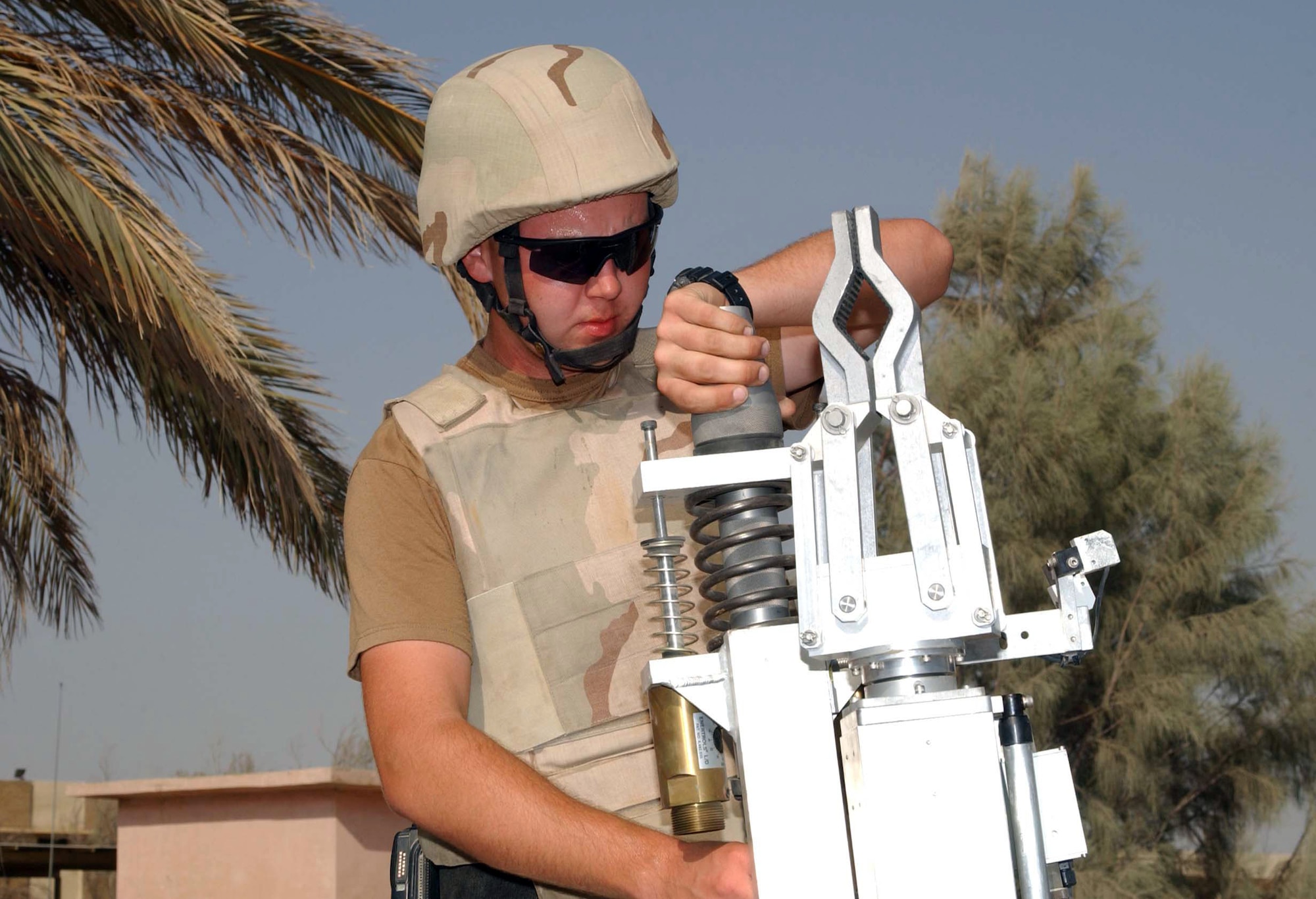 ALI BASE, Iraq -- Airman 1st Class Ian Wise installs an explosive cartridge into the firing attachment of a robot before it investigates a suspicious package found unattended on base.  He is an explosive ordnance disposal technician with the 407th Air Expeditionary Group.  (U.S. Army photo by Master Sgt. Lek Mateo)
