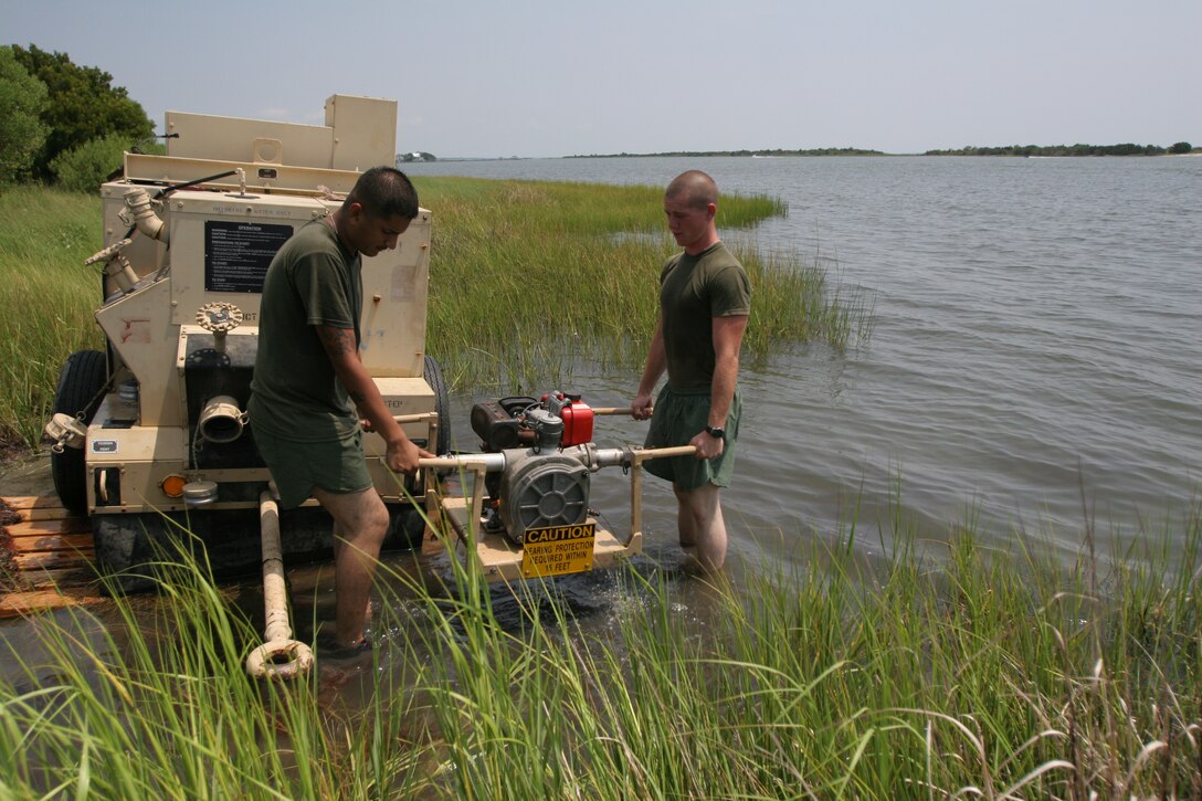Lance Cpl. Billy Hibdon and Lance Cpl. Cesar Bastidas, electrical Marines from Marine Wing Support Squadron 271 and Pfc. Spencer Dickson, a basic water technician from MWSS-271, work on a water pump during a field exercise, Aug. 9.