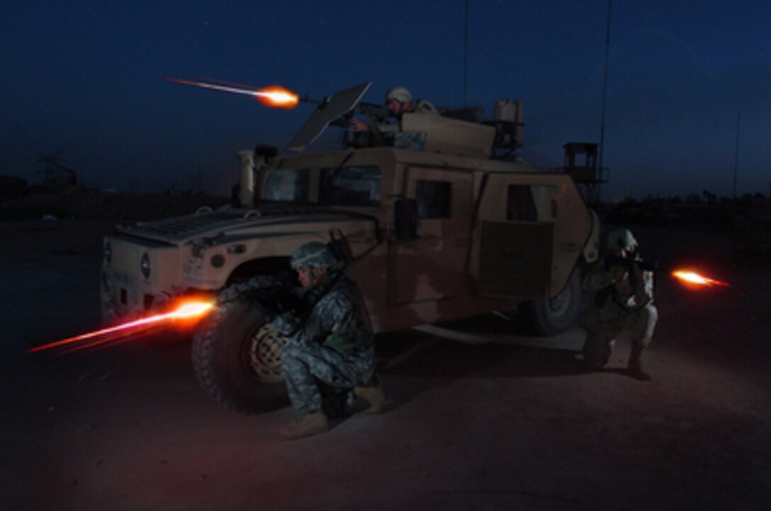 U.S. Army Spc. Ronnie Scibek (top), Sgt. Glenn Santos (left) and Spc. Kyle Hurt participate in a nighttime live fire training exercise at the Iraqi Army Compound firing range on Forward Operating Base Iskandariyah, Iraq, on July 30, 2005. The soldiers are attached to Bravo Company, 490th Civil Affairs Battalion, 155th Brigade Combat Team. 