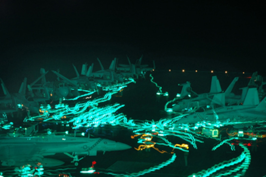 The flight deck of the aircraft carrier USS Kitty Hawk (CV 63) buzzes with activity as personnel and aircraft move about during night flight operations in the Pacific Ocean on Aug. 8, 2005. The USS Kitty Hawk Carrier Strike Group and the amphibious assault ship USS Boxer (LHD 4) are participating in the third annual Joint Air and Sea Exercise 2005 with the U.S. Air Force and Marine Corps in the western Pacific Ocean. The exercise focuses on integrated joint training proficiency in detecting, locating, tracking, and engaging units at sea, in the air, and on land. 