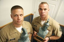 Holding busts of the Roman warriors who inspired the award, "Centurions" Staff Sgt. Ryan C. Easton, left, and Staff Sgt. Charles R. Rush earned the honored title Aug. 11, 2005, at Recruiting Station Des Moines, Iowa, for signing up 100 recruits each. The District's commanding officer, Col. Jeffery M. Peterson, presented each with the bust as well as a framed citation and certificate, during a ceremony witnessed by many of the RS's Marines as well as the recruiters' families. (Photo by Staff Sgt. Bill Lisbon)