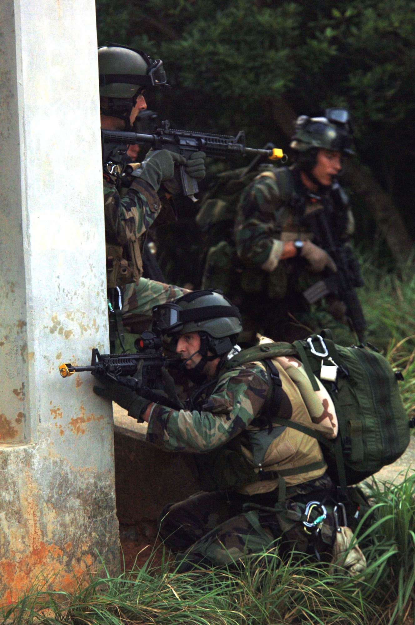 KADENA AIR BASE, Japan -- (From left) Senior Airmen Jonathan Courtright and Sean Cole provide cover for Tech. Sgt. Brandon Casteel as they search for "U.S. Embassy" personnel during Joint Air and Sea Exercise 2005 here. The Airmen are pararescuemen with the 31st Rescue Squadron. (U.S. Air Force photo by Master Sgt. Val Gempis) 
