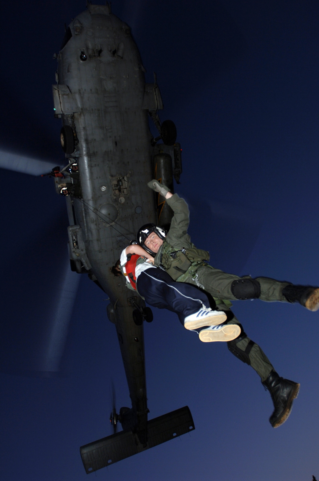 KADENA AIR BASE, Japan -- Airman 1st Class Mandy Fessel is &quot;rescued&quot; by a pararescueman from a Navy HH-60G helicopter during Joint Air and Sea Exercise 2005 here. The exercise provides an opportunity for air and naval forces to work together in a maritime environment. Airman Fessel is assigned to the 18th Medical Support Squadron. (U.S. Air Force photo by Master Sgt. Val Gempis)
