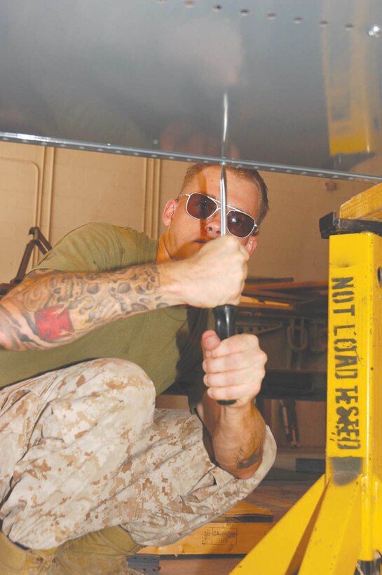 Pvt. Derek Burch, Marine Wing Support Squadron 371 heavy equipment mechanic and native of Salmon, Idaho, builds parts bins for the HE and motor transport maintenance shed at the Cannon Air Defense Complex Aug. 11. Burch is part of the squadron?s remain-behind platoon, a group of about a hundred Marines who could not deploy for various reasons. While the main body of the squadron has been in Iraq supporting Operation Iraqi Freedom II, the RBP moved the squadron?s base of operations to the complex, or P-111, and also performed their regular duties.