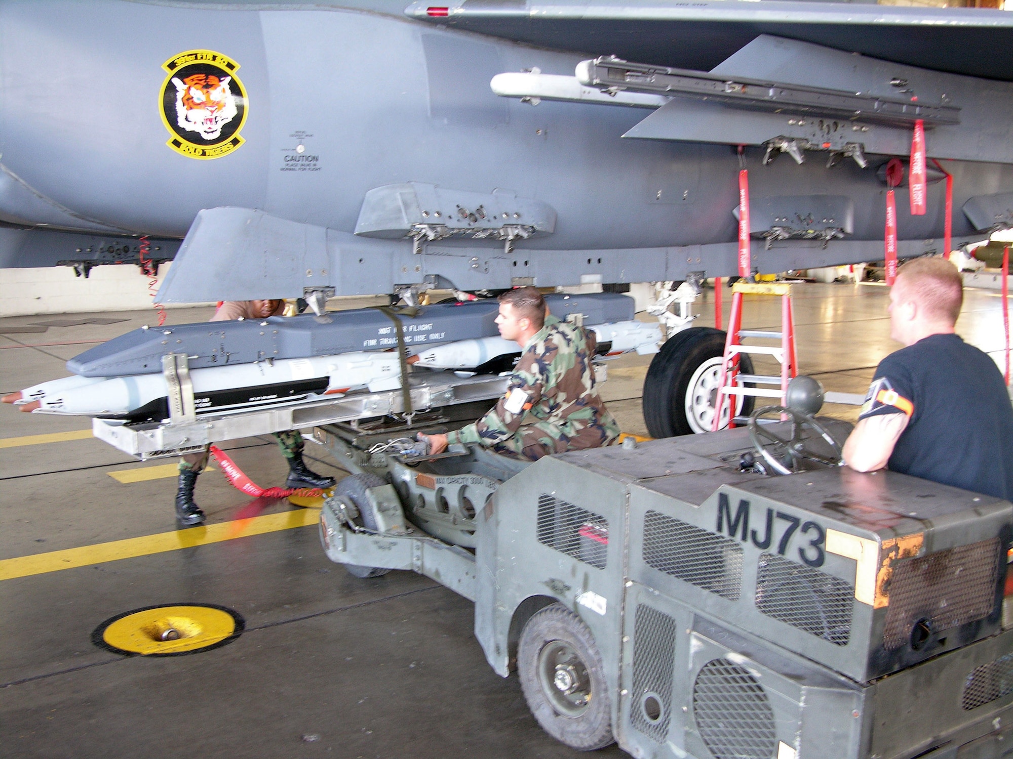 MOUNTAIN HOME AIR FORCE BASE, Idaho -- A load crew Airman here uses a jammer to attach a pair of GBU-39 bombs to an F-15E Strike Eagle.  An evaluation team trained and tested the crew on the new small diameter bomb.  (U.S. Air Force photo)