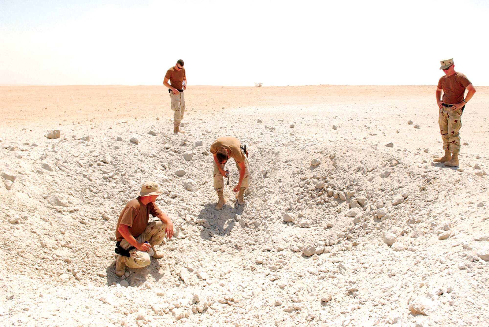 SOUTHWEST ASIA -- Explosive ordnance disposal Airmen with the 379th Expeditionary Civil Engineer Squadron inspect a crater after detonation to ensure no unexploded ordnance remains.  (U.S. Air Force photo by Airman 1st Class Desiree Hayden)