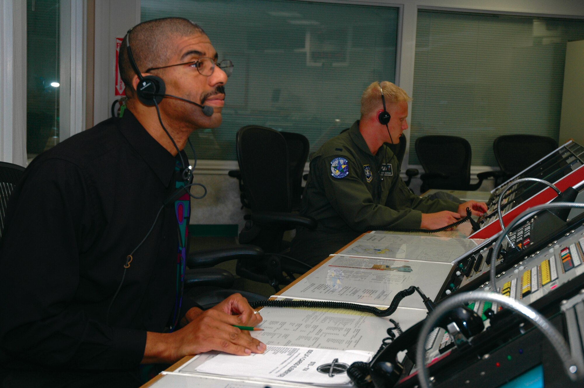 VANDENBERG AIR FORCE BASE, Calif. -- Wesley Fleming and 1st Lt. David Rodriguez pull an all-nighter at the Western Range Control Center here Aug. 9 to ensure the successful landing of the Space Shuttle Discovery. Mr. Fleming is a mission control supervisor, and Lieutenant Rodriguez is a 2nd Range Operations Squadron range control officer. (U.S. Air Force photo by Airman 1st Class Stephen Cadette)