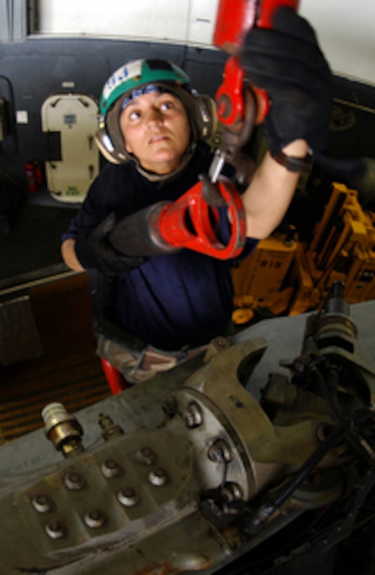 Navy Petty Officer 1st Class Natasja Vanderkleijn secures a sling to the engine of an SH-60 Seahawk helicopter before removing it for maintenance aboard the aircraft carrier USS Nimitz (CVN 68) on July 19, 2005. The Nimitz Strike Group is participating in Maritime Security Operations while underway in the Persian Gulf. Vanderkleijn is a Navy aviation machinist's mate attached to Helicopter Anti-Submarine Squadron 6 deployed onboard the Nimitz from Naval Air Station North Island, Calif. 