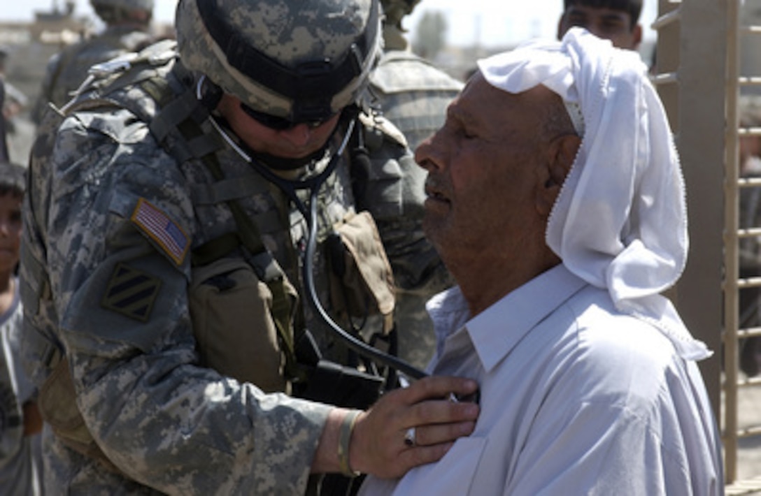 U.S. Army Doctor Capt. John Fulk listens to an Iraqi man's heart in the White Gold Village of West Baghdad, Iraq, on Aug. 5, 2005. Medical personnel and soldiers with 2nd Battalion, 130th Infantry Regiment, 256th Brigade Combat Team are providing medical assistance and toys to residents of the village. 