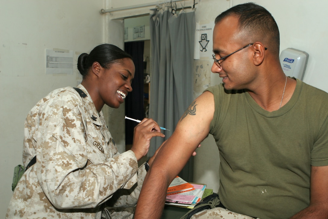 Petty Officer 2nd Class Roshun Green, corpsman and administrative chief, Fallujah Surgical Company, Combat Logistics Battalion 8, 2nd Force Service Support Group (FWD), administers an anthrax vaccine to a patient Aug. 12, 2005 here. Green has accomplished many goals since joining the Navy, and has more aspirations for the future.