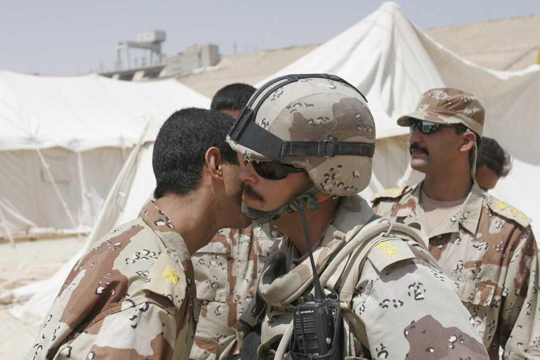 HADITHAH DAM, AL ANBAR, IRAQ (August 13, 2005) - Col. Muhammed greets an Iraqi lieutenant.  It is common for Iraqis to exchange kisses on the cheek as a greeting between close friends.  An odd number of kisses, usually more than three but fewer than seven are exchanged.