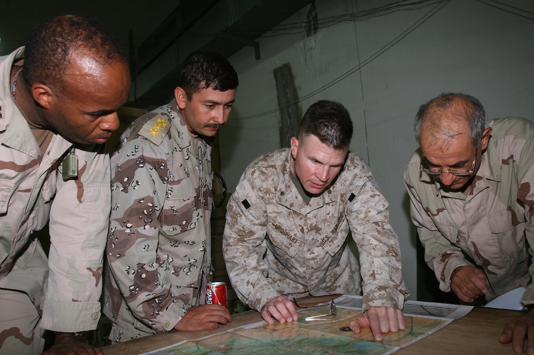 HADITHAH DAM, AL ANBAR, IRAQ (August 13, 2005) - Army Capt. Greg T. Brown, Iraqi Col. Muhammed, Lt. Col. Lionel B. Urquhart, and an Arabic translator pour over the details of a map.  The Iraqi Intervention Forces do not patrol on their own yet.  Matched up squad for squad with Marines, they provide extra boots on the ground with a natural understanding of Arabic language and culture.