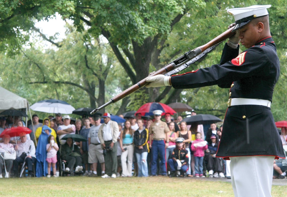 A Marine Corps Silent Drill Platoon member inspects an M-1 Garand rifle during a performance at the Illinois State Fair Aug. 14. The platoon performed for poolees, veterans and members of the community despite the steady rain.