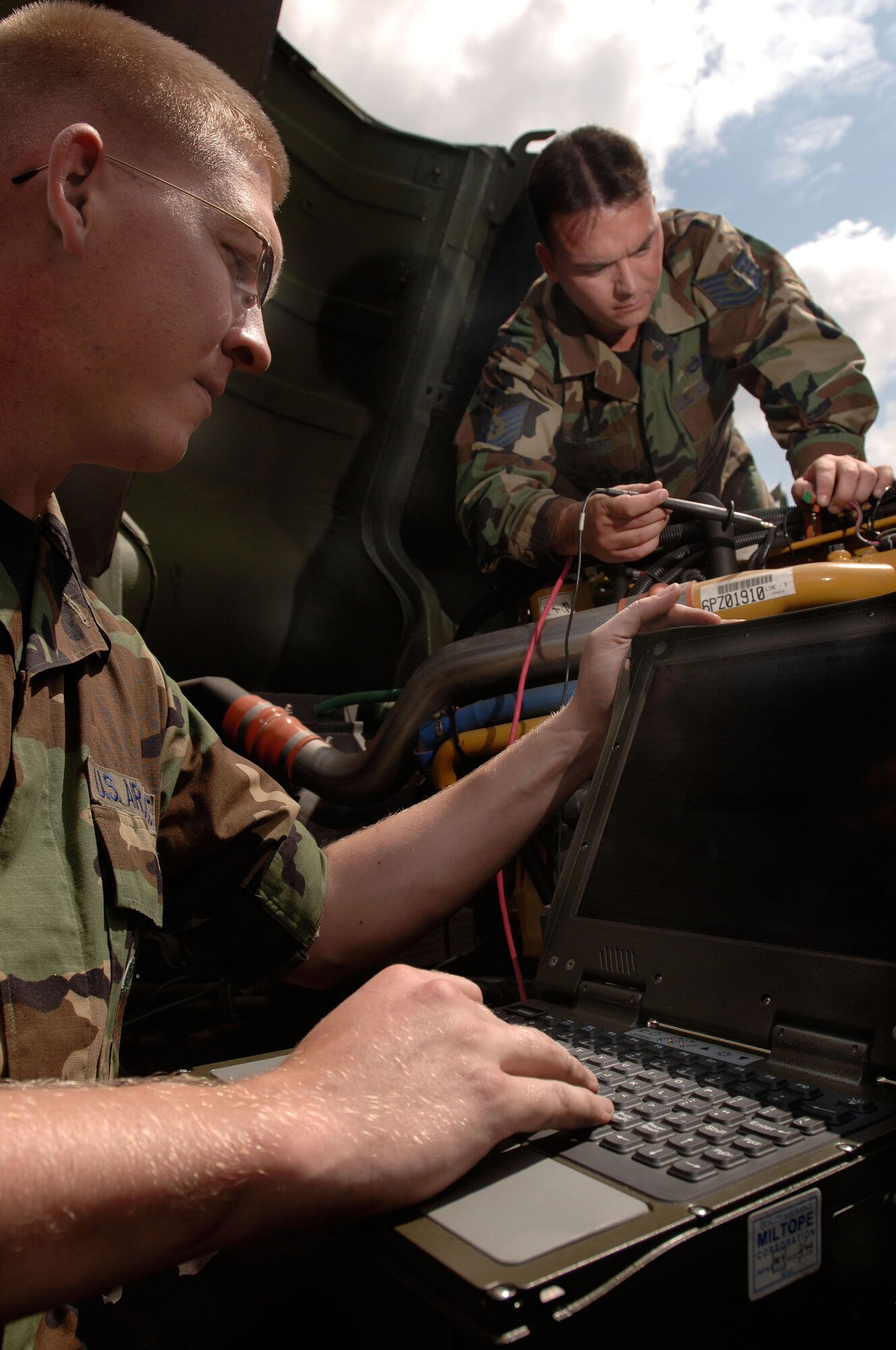 SULLIVAN BARRACKS, Germany -- Staff Sgt. Kyle Polencheck (left) analyzes data as Tech. Sgt. Jeffery Egbert checks a faulty sensor.  The information gives maintainers immediate data on engine sensors, trouble codes, drive train data, brake systems and fluid pressures on the light military tactical vehicle.  The system allows operators to isolate and identify problems in 30 minutes, where before it might have taken them a full day's work.  The Airmen are vehicle maintainers with the 4th Air Support Operations Squadron here.  (U.S. Air Force photo by Senior Master Sgt. Keith Reed)