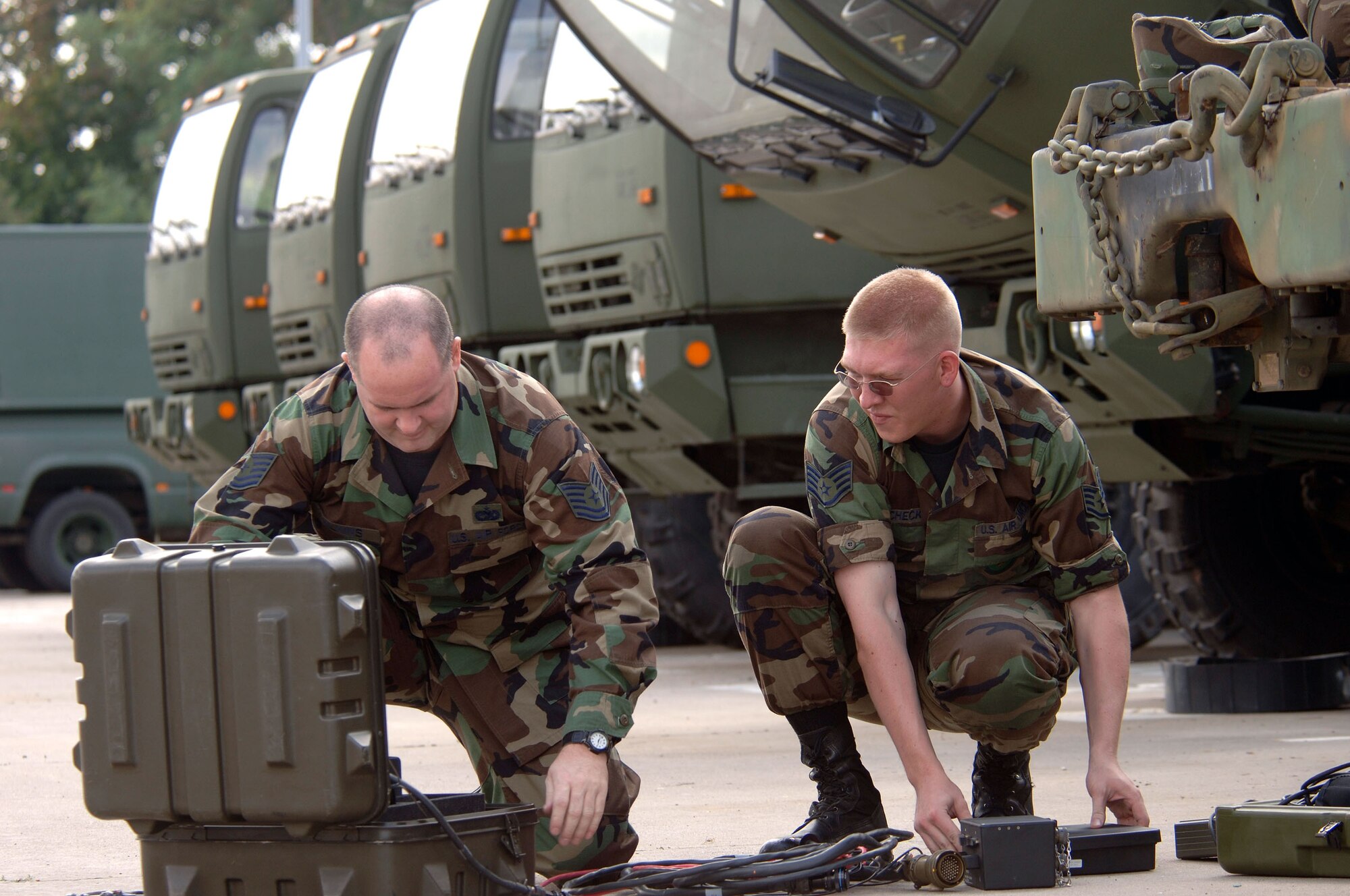 SULLIVAN BARRACKS, Germany -- Tech. Sgt. Hartzell Wilkins (left) and Staff Sgt. Kyle Polencheck place a maintenance support device into a hardened case for storage after servicing a truck.  The vehicle maintainers used the device to pinpoint a faulty engine sensor on a light military tactical vehicle in 20 minutes.  The $7,000 system saves thousands of manhours yearly, allowing vehicle maintenance operators here to more effectively manage their fleet of more than 85 vehicles.  The Airmen are assigned to the 4th Air Support Operations Squadron here.  (U.S. Air Force photo by Senior Master Sgt. Keith Reed)