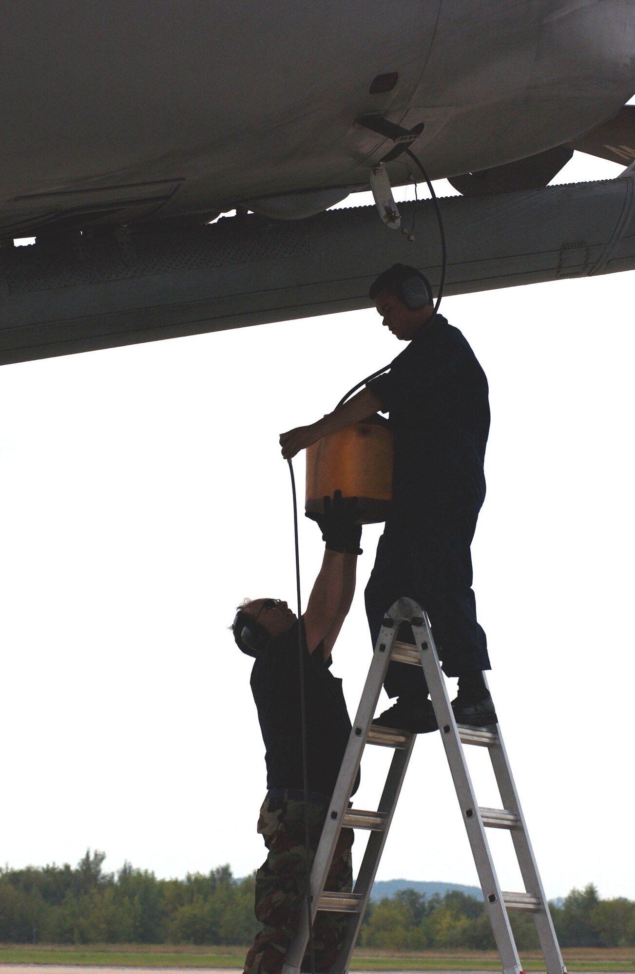 ZHUKOVSKY, Russia -- Tech Sgts. Anthony Alvarado (left) and Alex Gomez service a KC-10 Extender after landing at the Ramenskoye Airfield here for the Moscow International Aviation and Space Salon.  About 100 U.S. servicemembers are partipating in the air show Aug. 16 to 21.  The Airmen are crew chiefs from the 749th Aircraft Maintenance Squadron at Travis Air Force Base, Calif.  (U.S. Air Force photo by Master Sgt. Mona Ferrell)