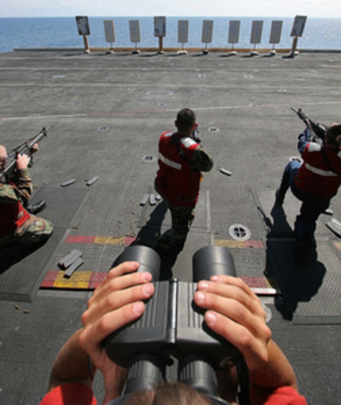 A firing line safety observer uses binoculars to check for target accuracy while sailors fire M-16 rifles during a small-arms qualifications aboard the Nimitz-class aircraft carrier USS Harry S. Truman (CVN 75) while underway in the Atlantic Ocean on Aug, 1, 2005. Truman is conducting carrier qualifications and sustainment operations off the East Coast. 