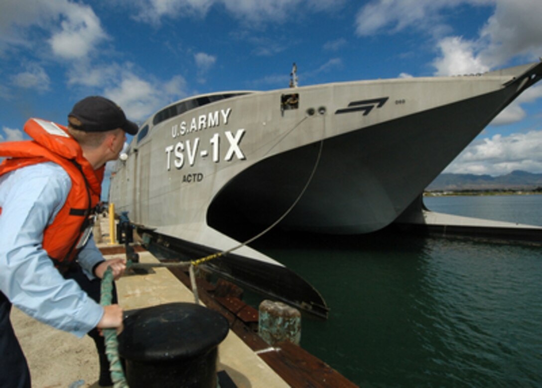 Navy Petty Officer 3rd Class Erik Horner casts off a mooring line as the U.S. Army's Theater Support Vessel-1X USAV Spearhead gets underway from Ford Island at Pearl Harbor, Hawaii, on Aug. 11, 2005, to conduct a capabilities demonstration. The 98-meter aluminum-hulled catamaran can maneuver personnel with their equipment from staging bases to remote locations at speeds of up to 40 knots. Horner, is a Navy cryptological technician-technical assigned to the USS Lake Erie (CG 70). 