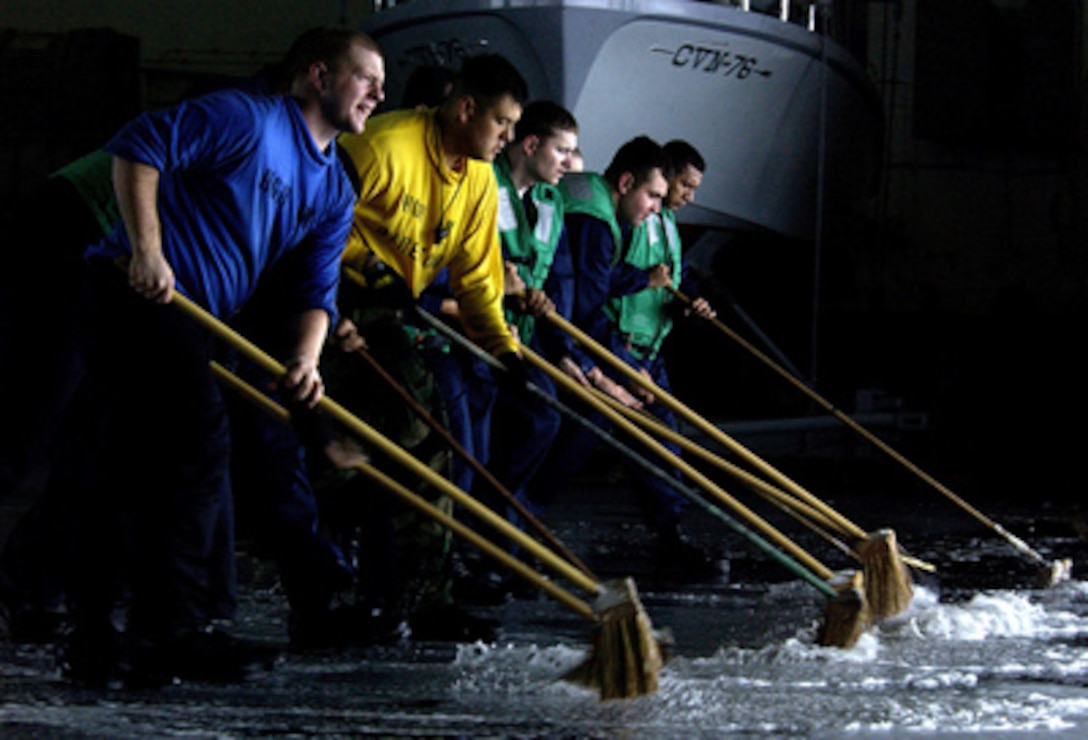 Sailors conduct a hangar bay scrub down aboard the Nimitz-class aircraft carrier USS Ronald Reagan (CVN 76), on Aug. 11, 2005. The Ronald Reagan is underway in the Pacific Ocean conducting carrier qualifications for the West Coast fleet replacement squadrons. 