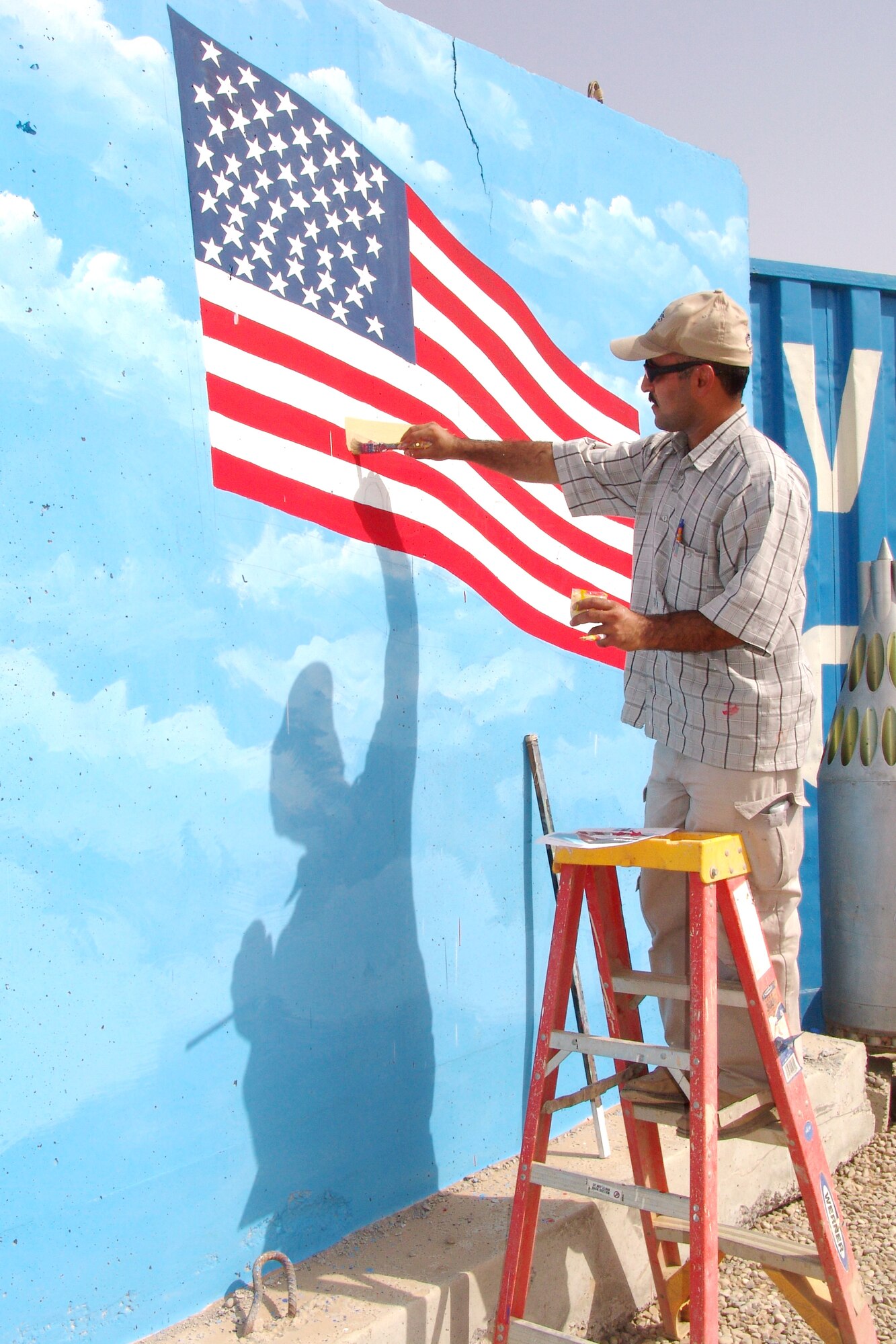 KIRKUK AIR BASE, Iraq -- A local national paints the mural that will stand as a memorial to Airman 1st Class Carl Anderson and Staff Sgt. Dustin Peters. Airman Anderson and Sergeant Peters died while providing security escort for convoys in Iraq. (U.S. Air Force photo by Tech. Sgt. J. LaVoie)
           