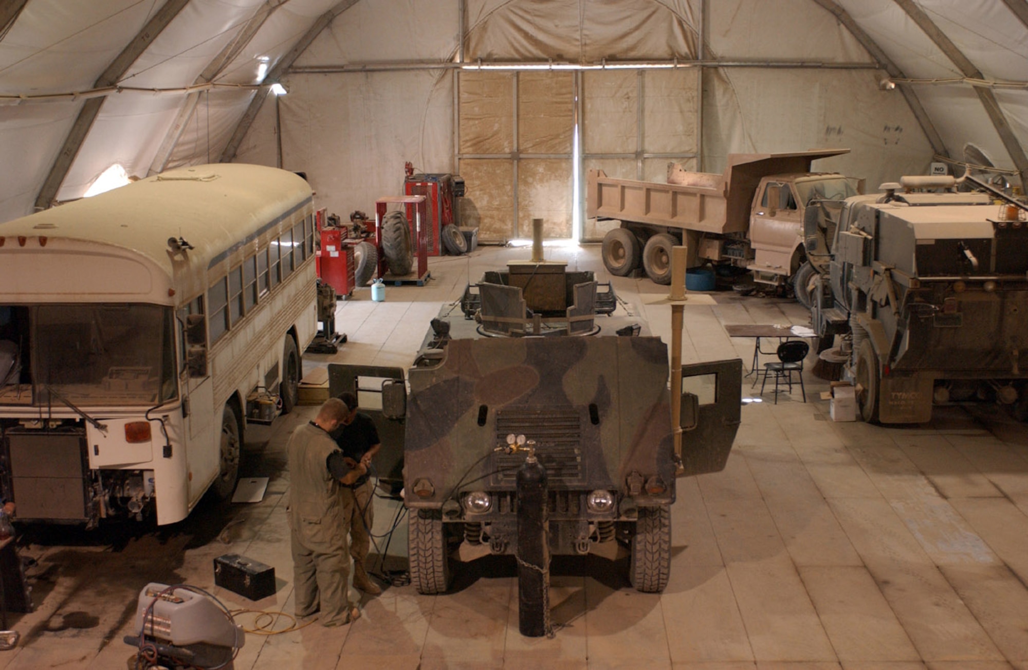 BAGHDAD, Iraq -- Grease and grime are unavoidable in the 447th Expeditionary Logistics Readiness Squadron's vehicle maintenance facility here.  Every day an ever-changing line of trucks, buses, Humvees and other vehicles can be found waiting their turn for repair.  (U.S. Air Force photo by Tech. Sgt. Brian Davidson)