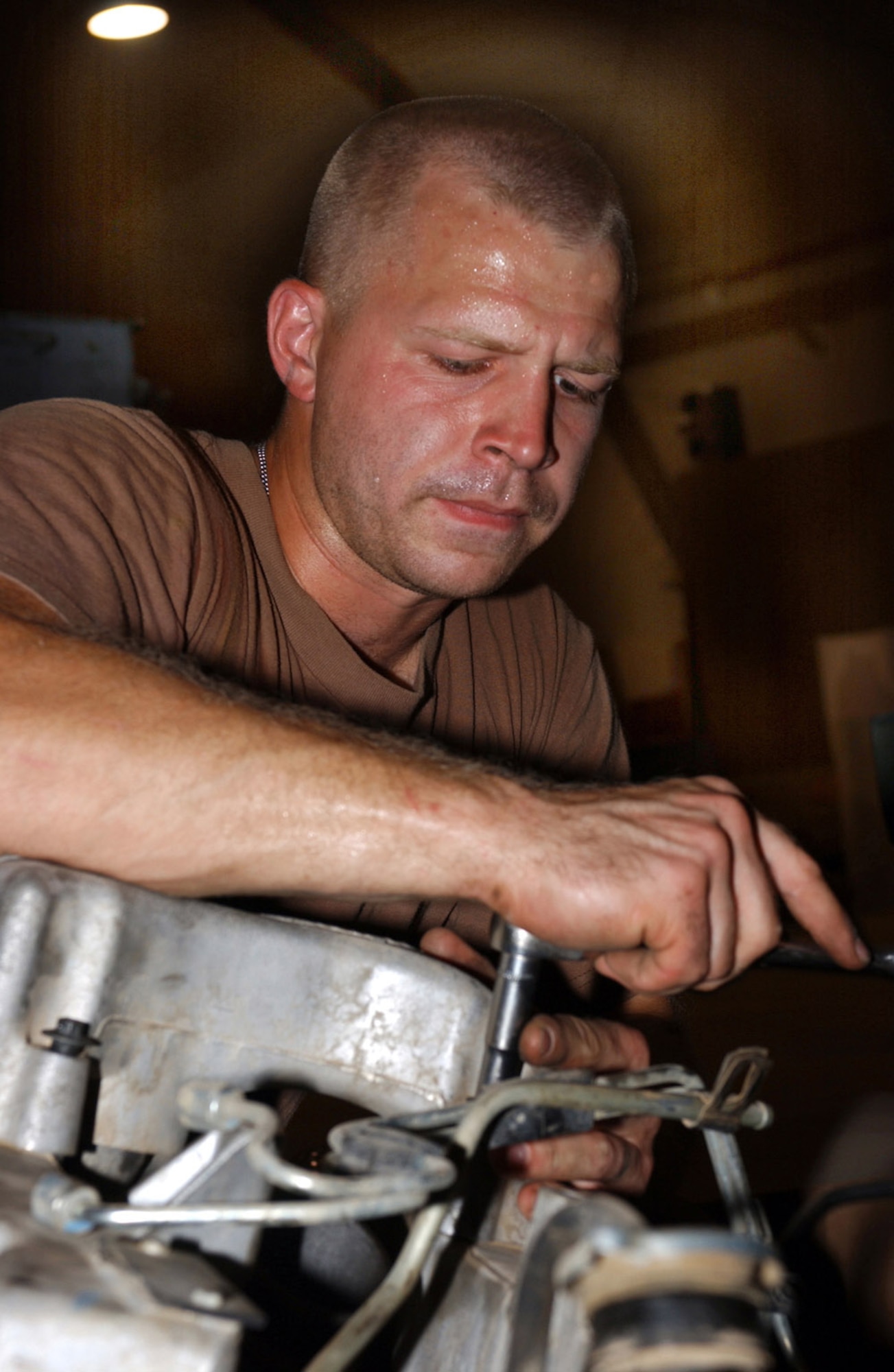 BAGHDAD, Iraq -- Staff Sgt. Shawn Thompson installs a turbocharger during a Humvee engine change here.  He is a vehicle mechanic with the 447th Expeditionary Logistics Readiness Squadron and is deployed from Kadena Air Base, Japan.  (U.S. Air Force photo by Tech. Sgt. Brian Davidson)               