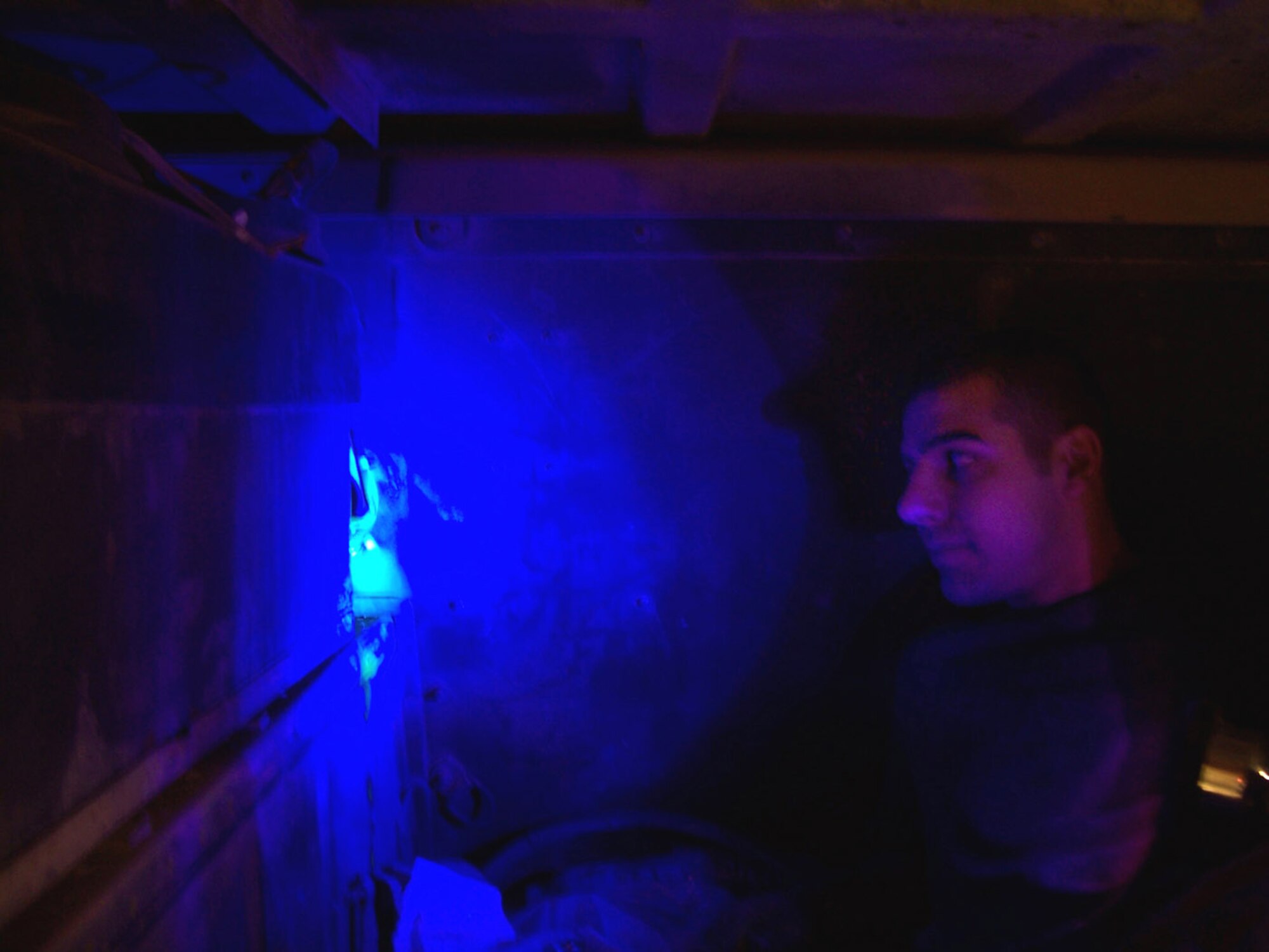 BAGHDAD, Iraq -- Staff Sgt. Dustin Barnhardt uses a special dye and infrared light to find an air-conditioning leak on a Humvee here.  He is a vehicle mechanic with the 447th Expeditionary Logistics Readiness Squadron and is deployed from Kadena Air Base, Japan.  (U.S. Air Force photo by Tech. Sgt. Brian Davidson)
