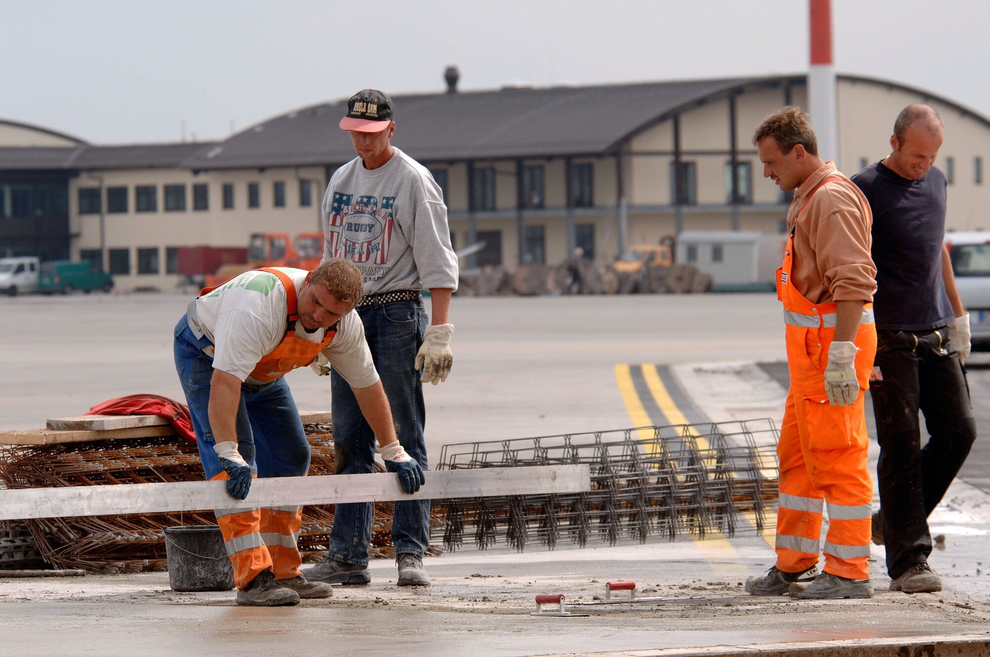 SPANGDAHLEM AIR BASE, Germany -- German contract construction workers replace a damaged concrete slab on the new Air Mobility Command ramp here.  The building in the back is the new home of the 726th Air Mobility Squadron, which is moving to the base as part of the Rhein-Main Transition Program.  The squadron will begin airlift support operations Oct. 1.  (U.S. Air Force photo by Senior Master Sgt. Keith Reed)