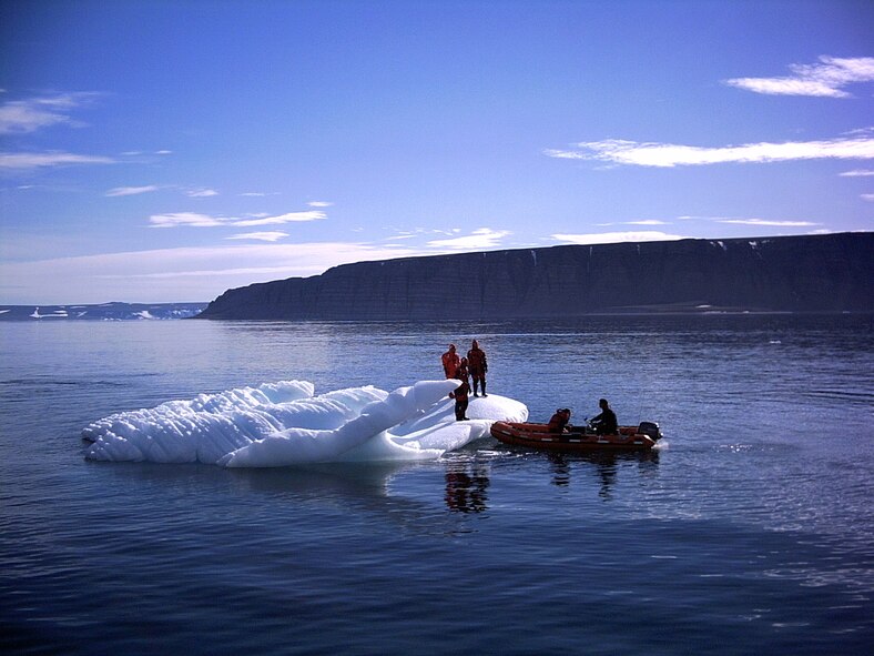 THULE AIR BASE, Greenland -- Airmen explore an iceberg in 30-degree water during a demonstration of Danish Police water survival suits.  The team dove into the Arctic Ocean during an "open ship" event aboard the Sisak IV, a cutter from Sisimiut, Greenland.  (U.S. Air Force photo)