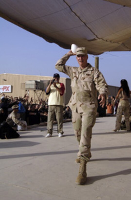 Chairman of the Joint Chiefs of Staff Gen. Richard B. Myers, U.S. Air Force, throws a football into an audience of Army soldiers during a United Service Organizations show at Camp Arifjan, Kuwait, on Aug. 16, 2005. Myers is in the midst of a 10-day trip around the world to meet with servicemembers and assess troop morale. Fox Sports television personality and cover girl Leeann Tweeden, NFL Hall of Fame member Gale Sayers, and comedians Jeffrey Ross and Colin Quinn are accompanying Myers as he thanks the service men and women for their sacrifices. 