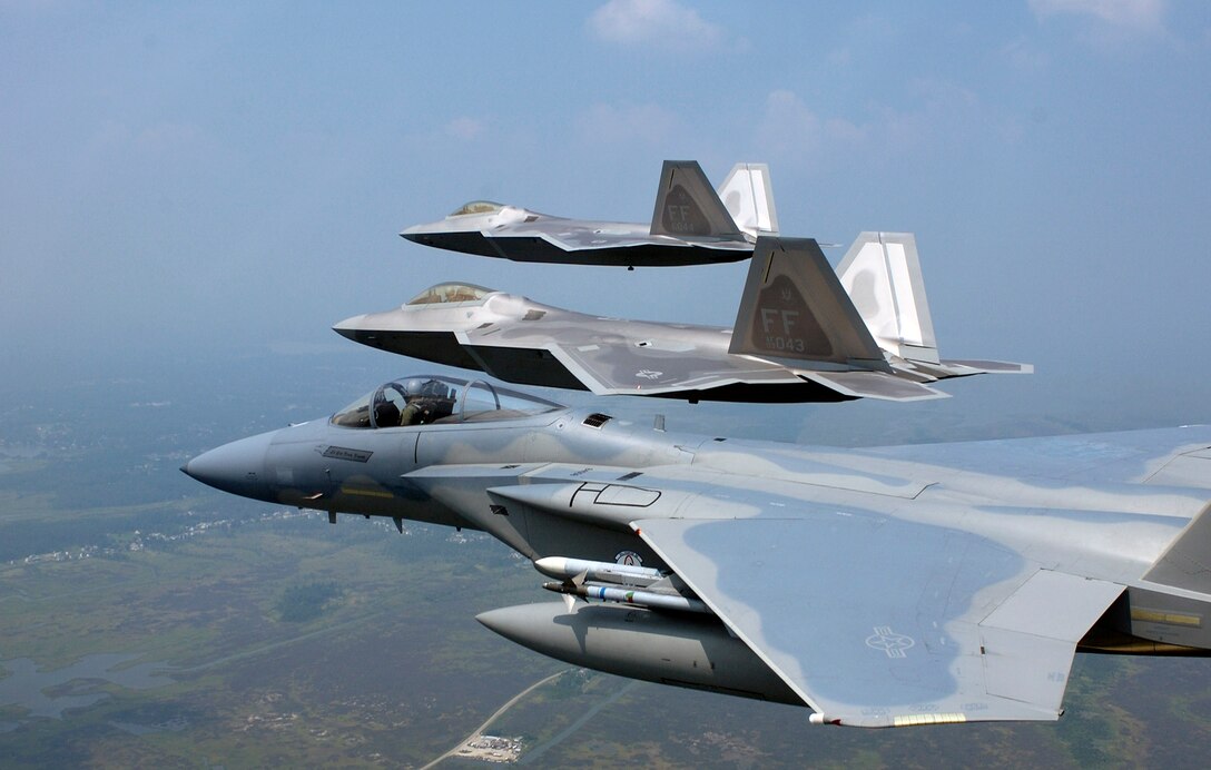LANGLEY AIR FORCE BASE, Va. -- Two F/A-22 Raptors and a F-15 Eagle fly in formation during a training sortie here.  The 27th Fighter Squadron currently has five permanently assigned Raptors.  (U.S. Air Force photo by Tech. Sgt. Ben Bloker)