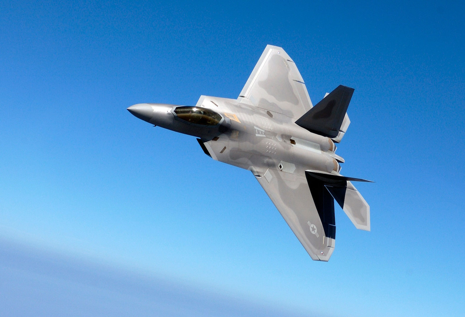 LANGLEY AIR FORCE BASE, Va. -- Lt. Col. James Hecker banks his F/A-22 Raptor during a training sortie here.  He is the 27th Fighter Squadron commander.  (U.S. Air Force photo by Tech. Sgt. Ben Bloker)