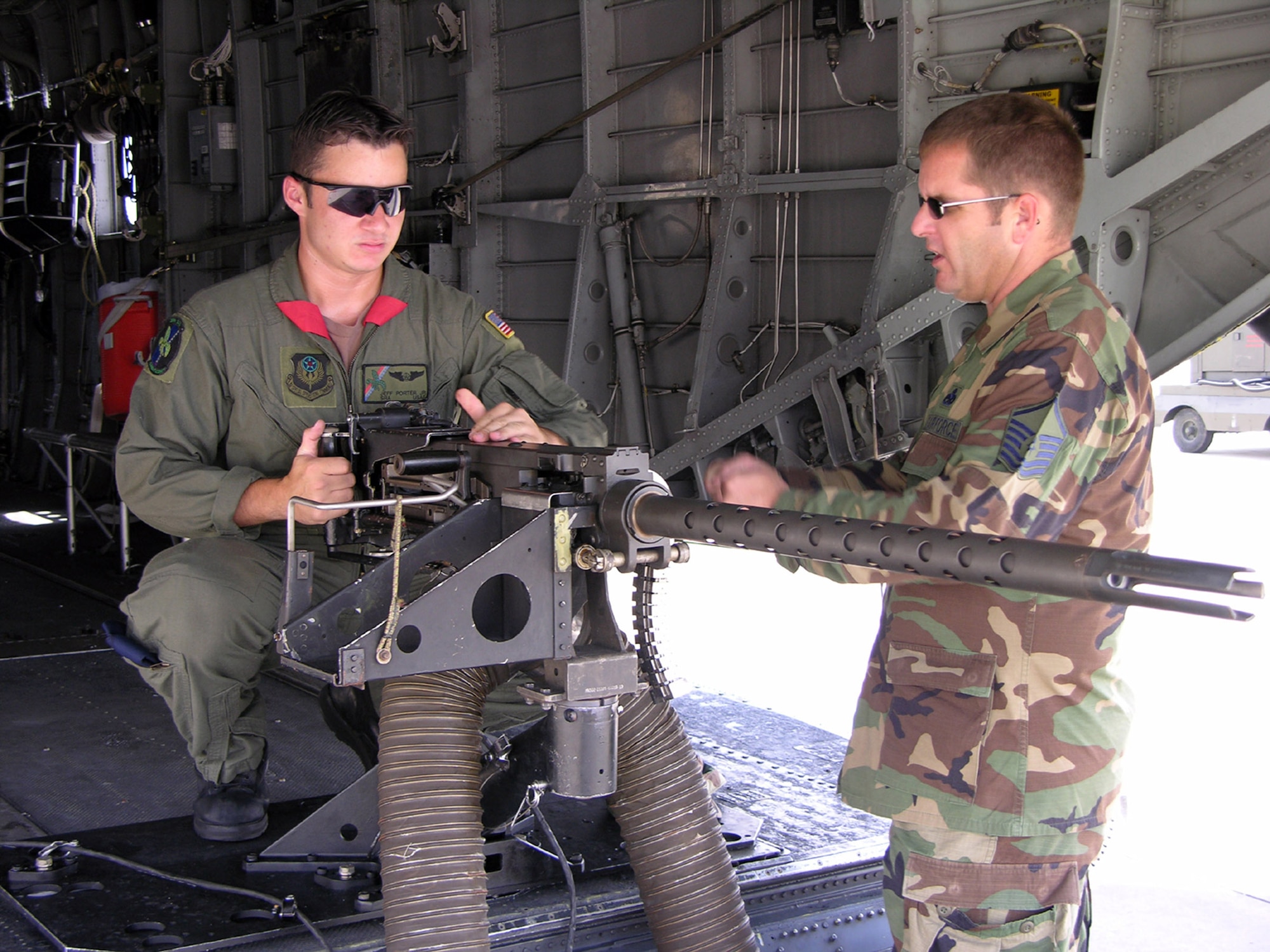 HURLBURT FIELD, Fla. -- Senior Airman Jeffrey Porter shows his father, Master Sgt. Jeffrey Porter, how a .50 caliber machine gun works.  Airman Porter is a gunner with the 20th Special Operations Squadron, and Sergeant Porter is a radio maintainer with the 720th Operations Support Squadron.  (U.S. Air Force photo by Staff Sgt. Holly Reid)