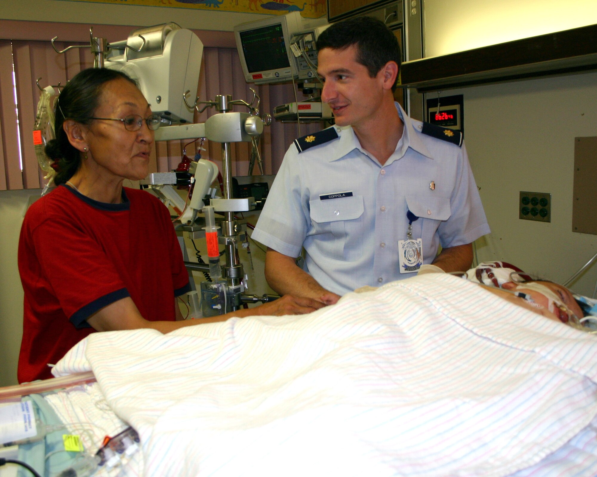 LACKLAND AIR FORCE BASE, Texas -- Maj. (Dr.) Christopher Coppola and Dora Hill discuss her son's status at Wilford Hall Medical Center.  Dr. Coppola, a pediatric surgeon with the 859th Surgical Operations Squadron, was part of the team that flew to Anchorage, Alaska, on Aug. 14, in an attempt to save Michael's life.  (U.S. Air Force photo by Sue Campbell)