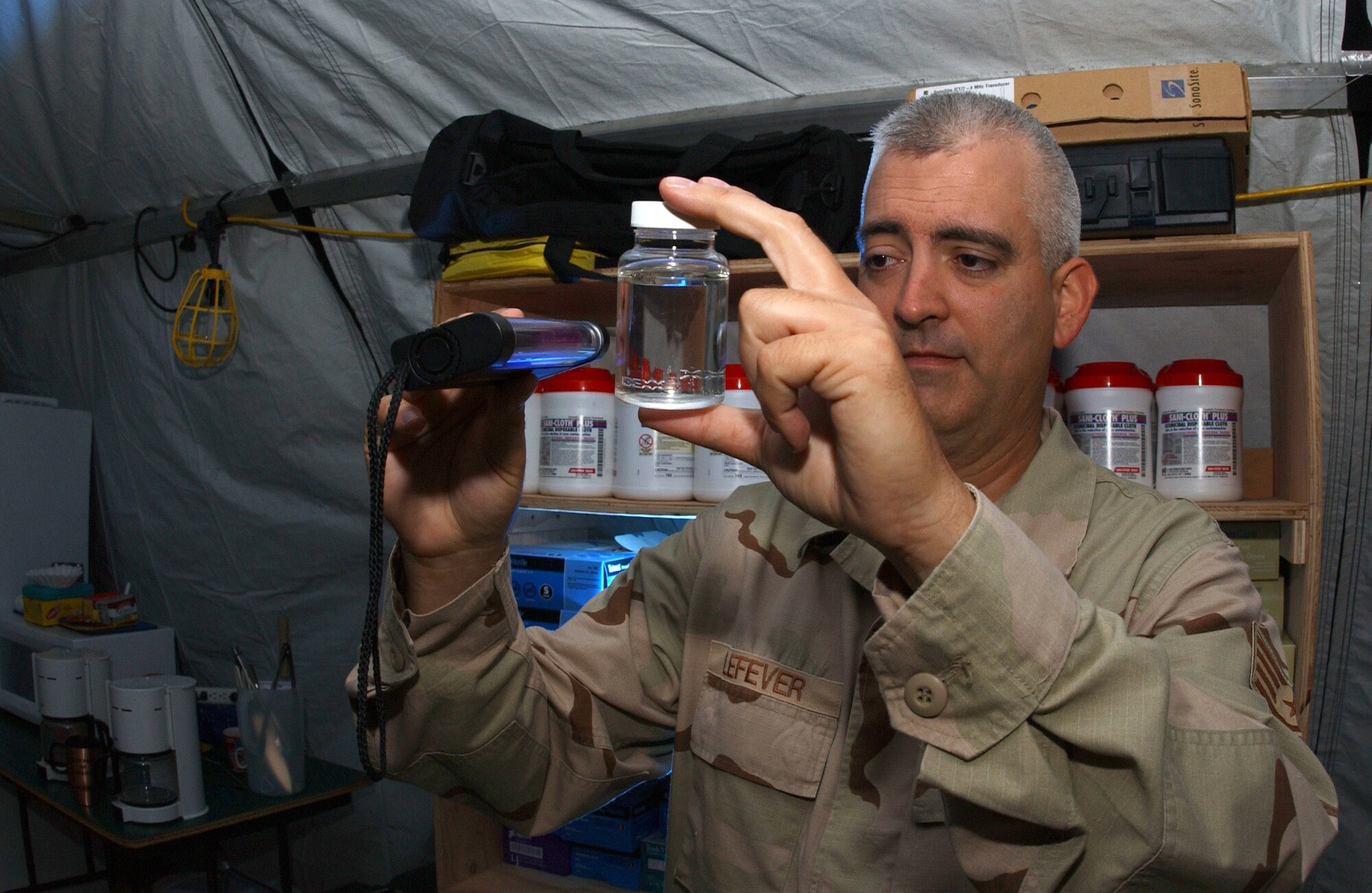 OPERATION ENDURING FREEDOM -- Staff Sgt. Mark Lefever looks for bacteria in a water sample using a black light. He is a bioenvironmental engineer with the 40th Air Expeditionary Group at a forward-deployed location and is from Robins Air Force Base, Ga. (U.S. Air Force photo by Staff Sgt. Jocelyn Rich) 
                        