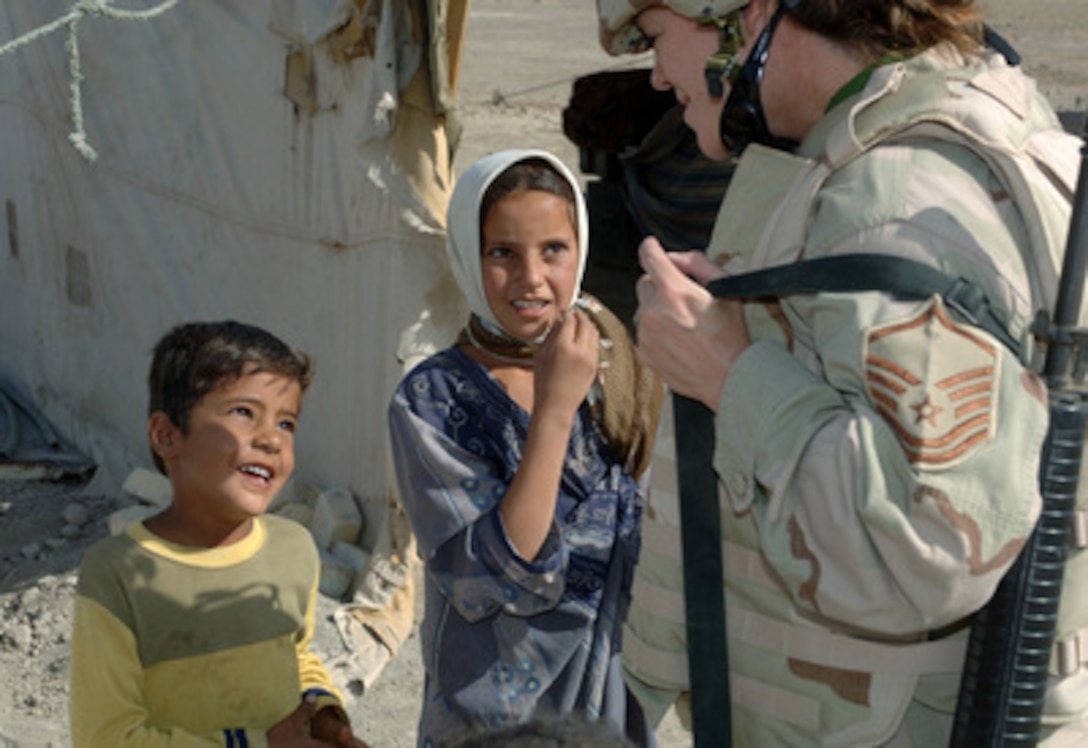 U.S. Air Force Master Sgt. Jennifer Smith talks with two Bedouin children during an operation to give local Bedouins donated food and clothing at Ali Base, Iraq, on Aug. 10, 2005. Smith is assigned to the 407th Expeditionary Operation Support Squadron at Ali Base, Iraq. 