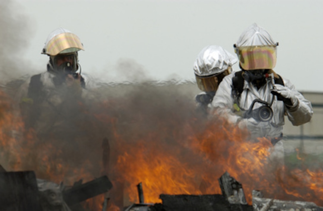 Iowa U.S. Air National Guard firefighters approach a fire in a simulated aircraft emergency during an operational readiness exercise in Sioux City, Iowa, on Aug. 12, 2005. The firefighters are attached to the 185th Air Refueling Wing. 